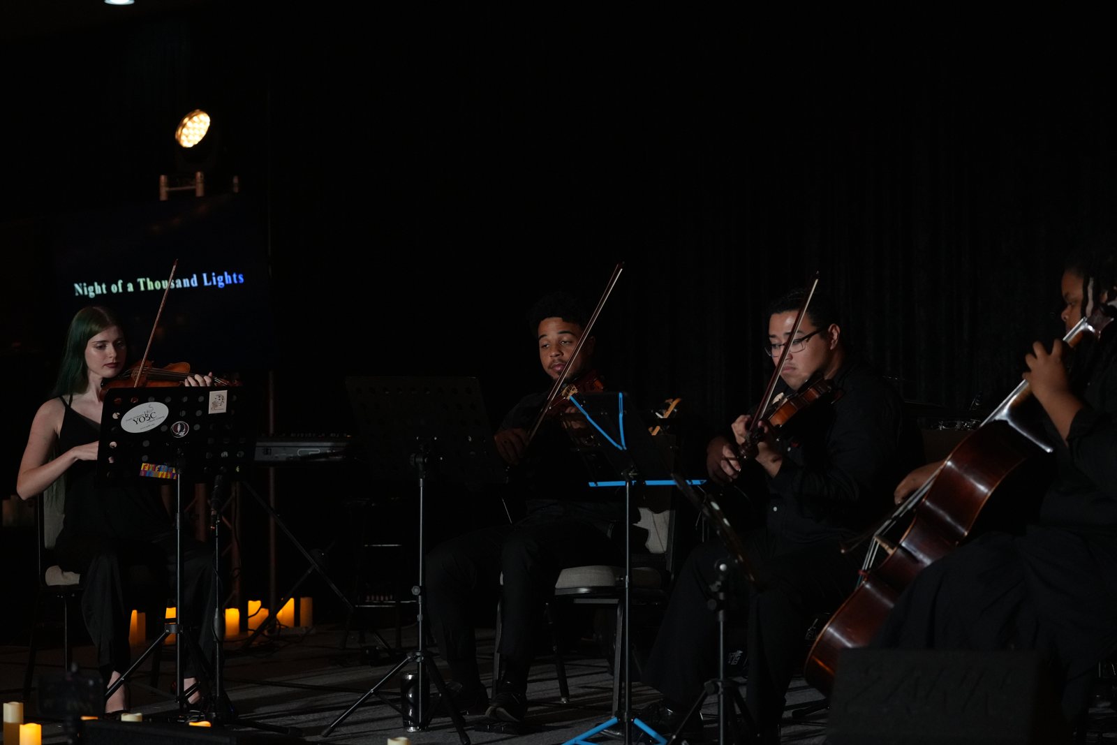 The string quartet plays beneath the Night of a Thousand Lights screen
