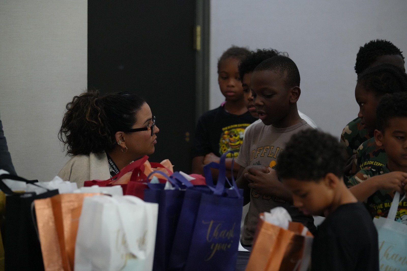 Children gathered around a table of gift bags