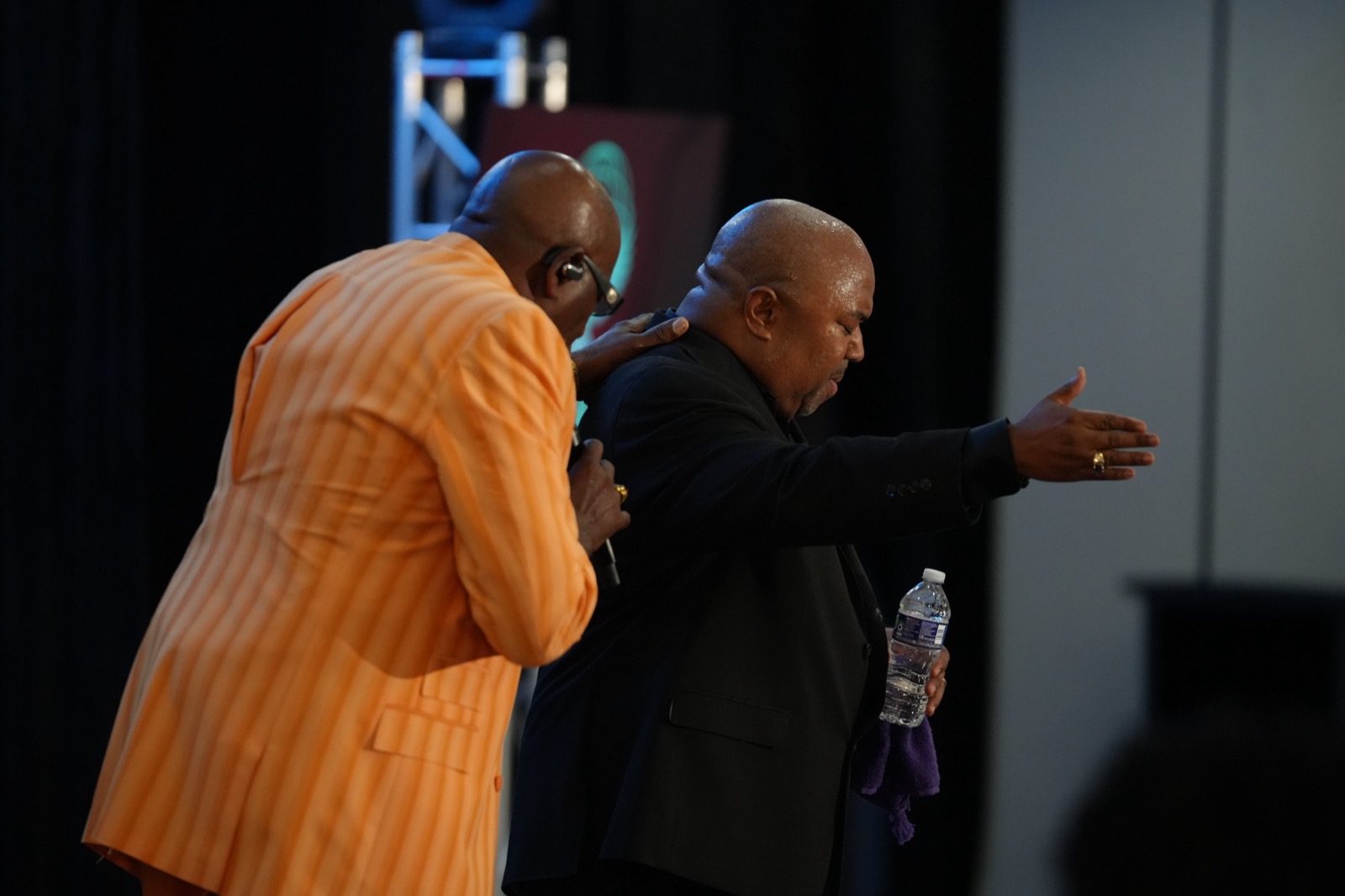 Two ministers pray together during an evening service