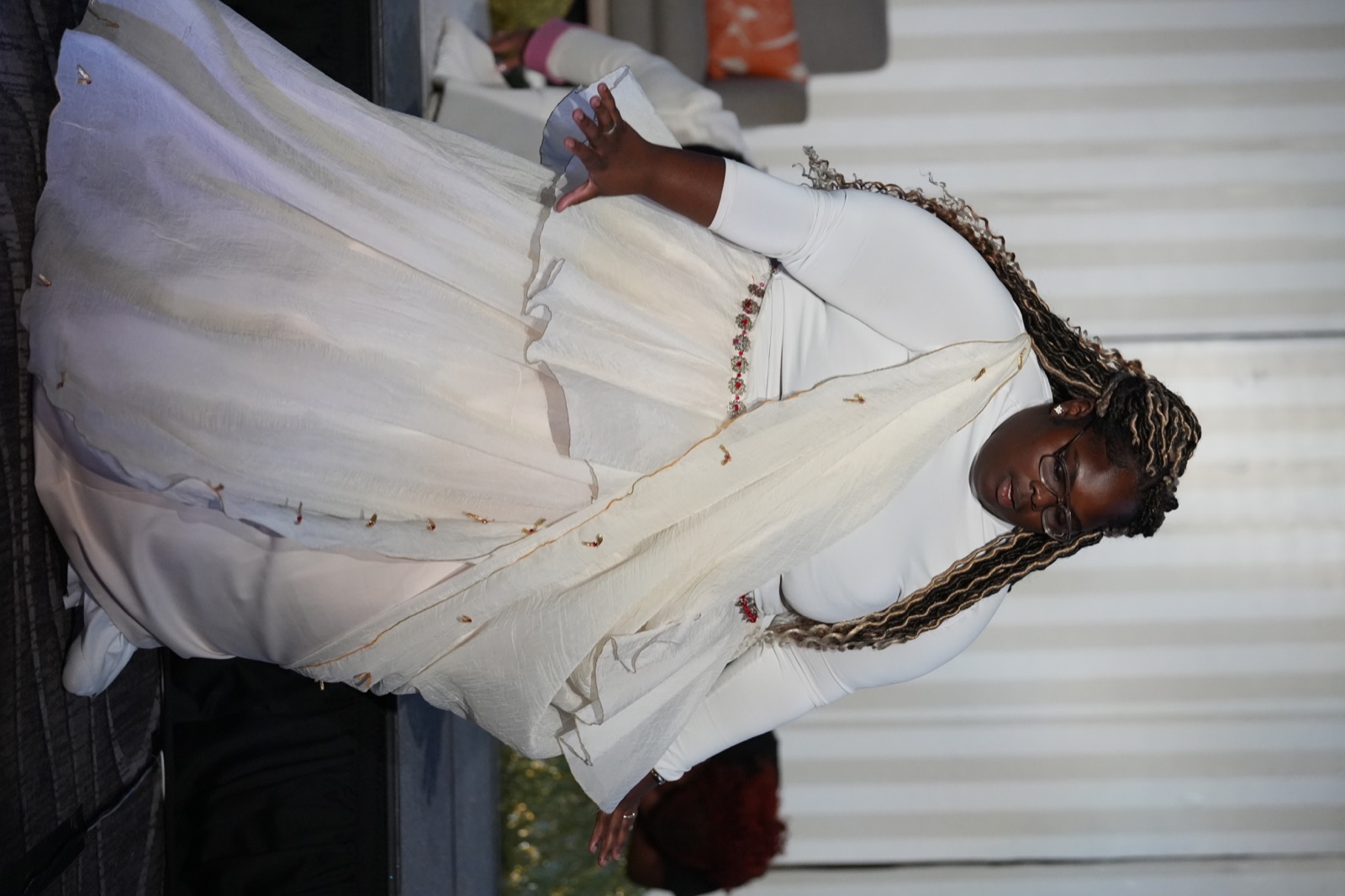 A dancer in layered white and gold performs during the Full Flame Production