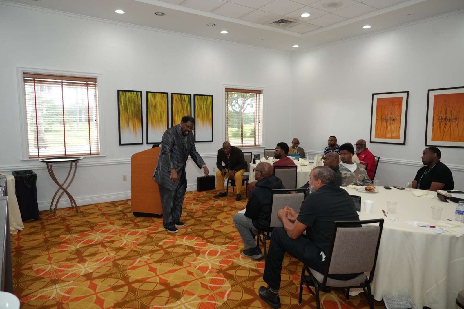 A minister teaches men gathered around tables during Gideon’s Band