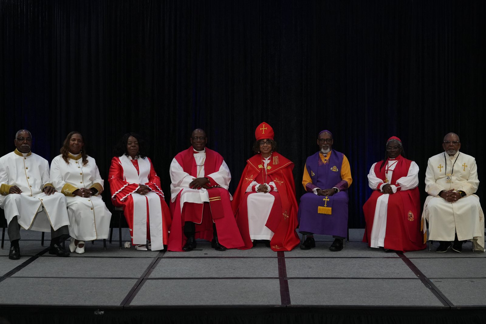 The presbytery sits across the platform in red, white and purple vestments
