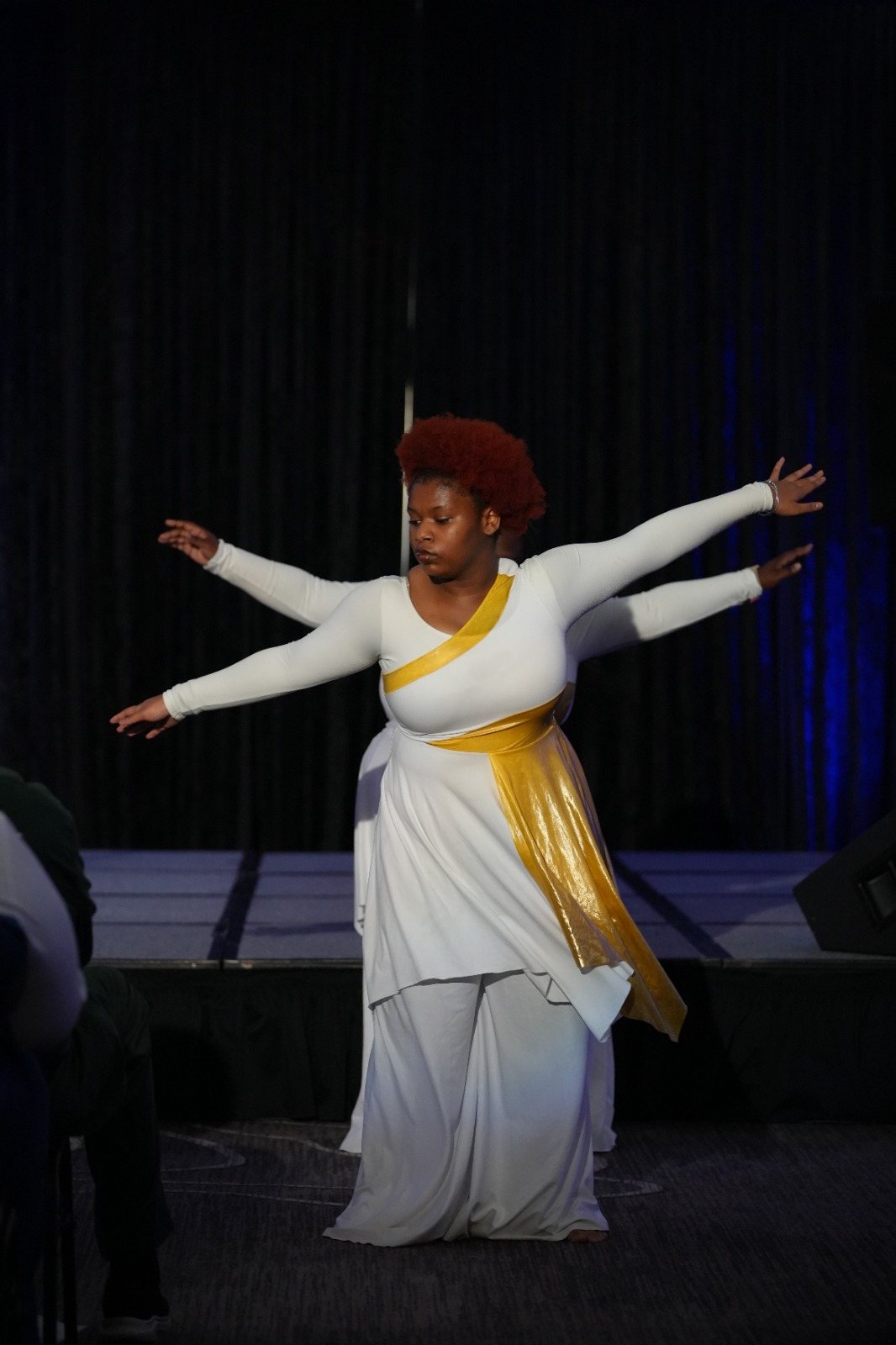 A dancer ministers in white and gold during the convention