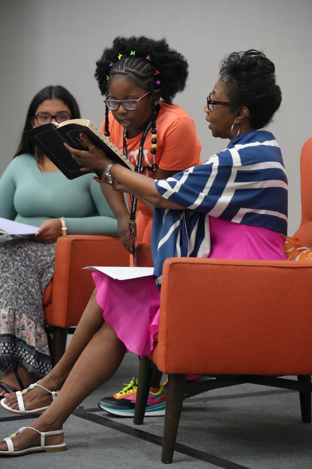A woman reads scripture with another participant during a ministry moment