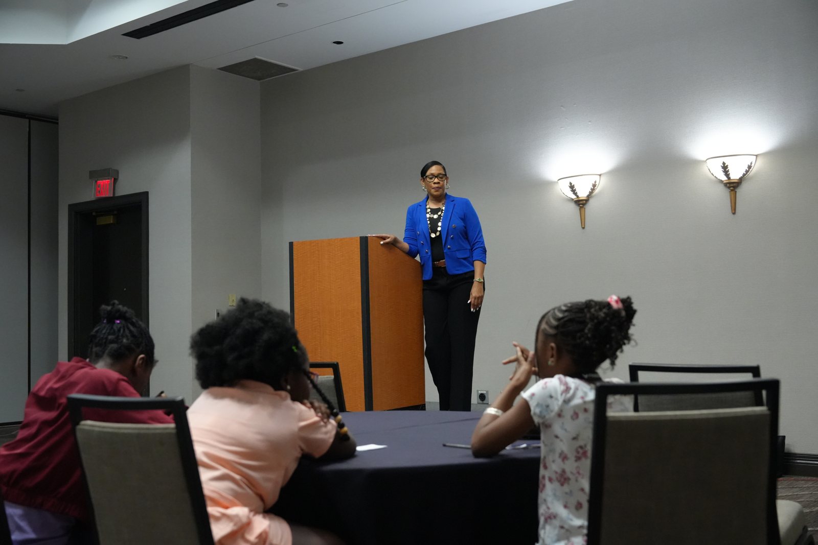 A young participant raises a hand during a NextGen discussion