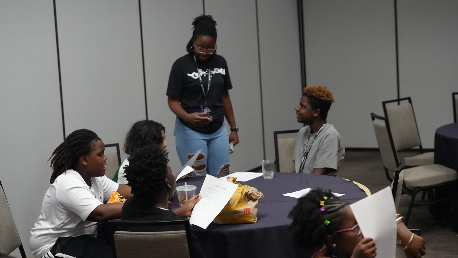 A facilitator leading a table of young people through a worksheet during a youth workshop at FreedomGRC 2026